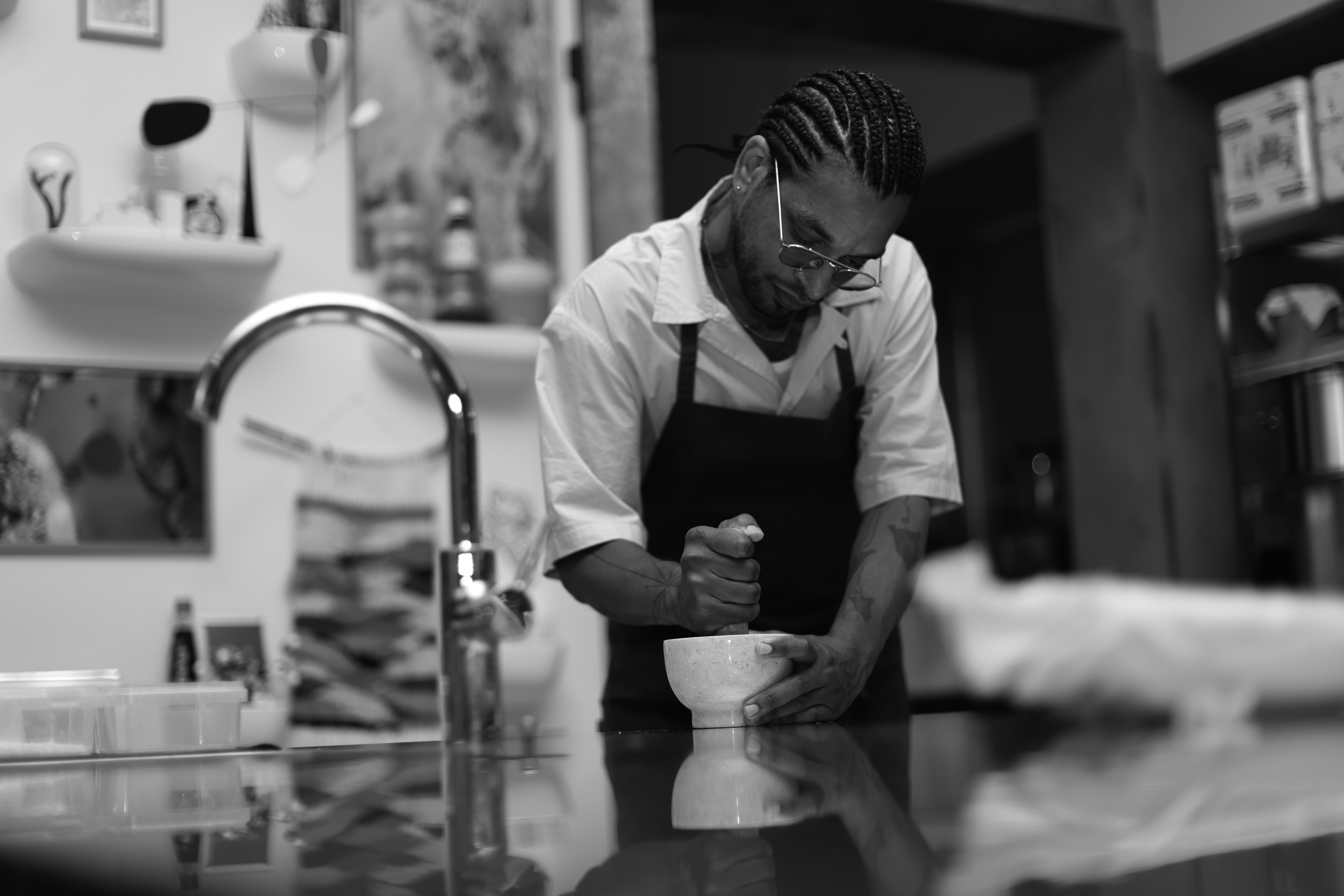A black and white photograph of a chef working in the kitchen, an image by David Zilber